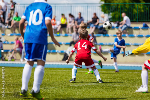 Running Soccer Football Players. Soccer Kick; School Football Game. Footballers Kicking Football Match; Young Soccer Players Kicking Ball. Footballers in Jersey Shirts. Spectators in the Background