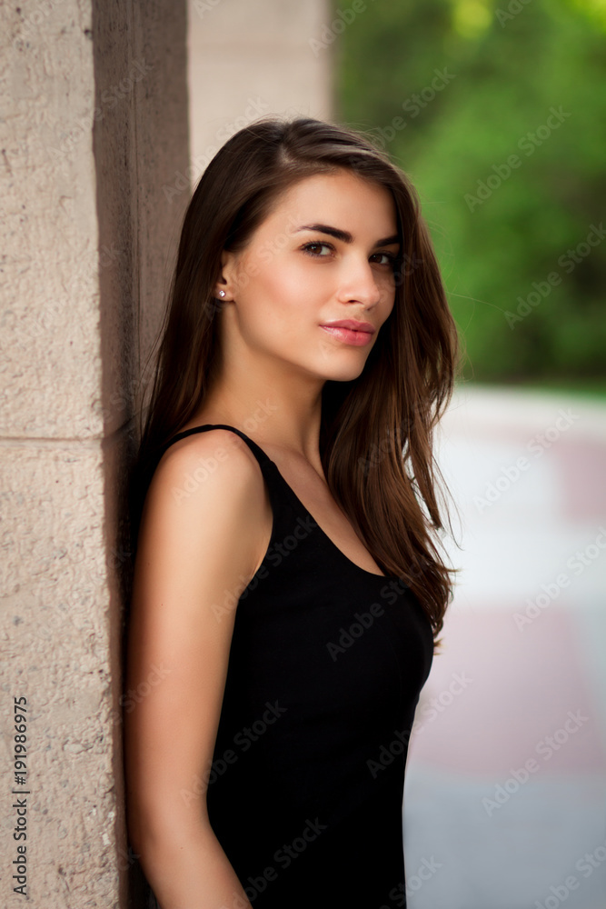 Fototapeta premium beautiful summer girl on the street in black dress, elegant girl in dress