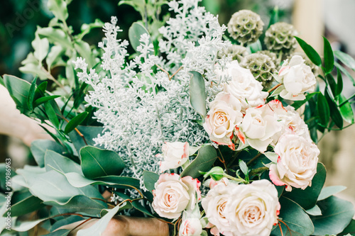 Wedding bouquet of white pink roses on flower shop background