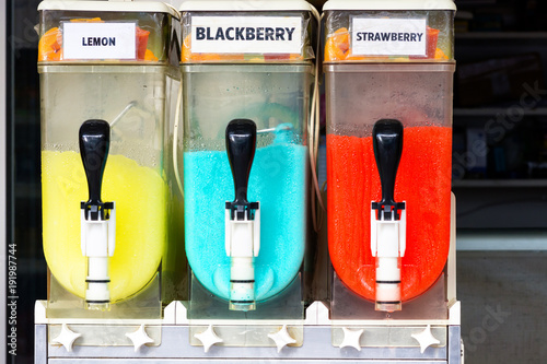 Colorful canisters of refreshing frosty cold slush ice drinks