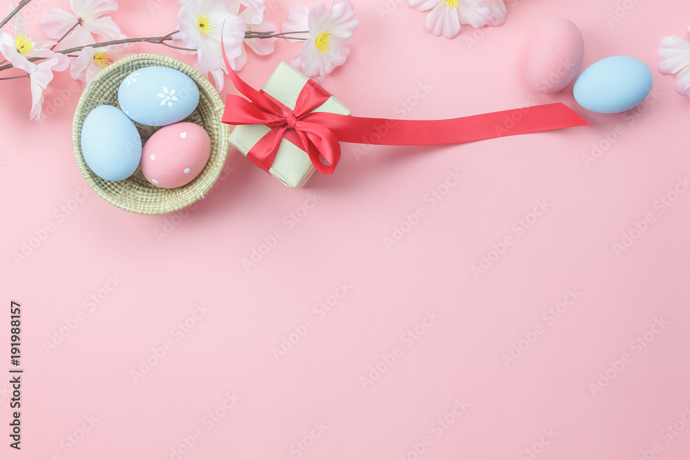 Table top view shot of decorations Happy Easter holiday background concept.Flat lay bunny eggs with flower and gift box on modern pink paper at office desk.Blank space design for mock up.pastel tone.