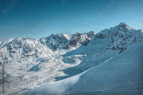 Nice mountains view at sunny day with skiers under blue sky with © Andrii IURLOV