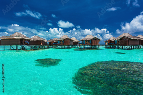 Over water bungalows with steps into coral lagoon