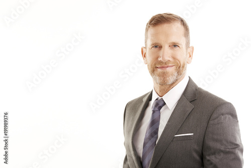 Smiling businessman portrait. Successful senior manager business man wearing suit while standing against at isolated white background. 