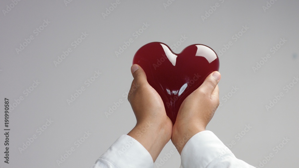 Fototapeta premium jelly-like red heart in man's hand holding it gently