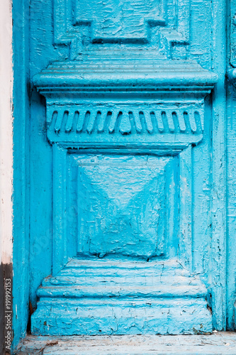 Close-up the Element of blue many times painted cracked double-barreled wooden vintage door of the last century with a post slit. © yanik88