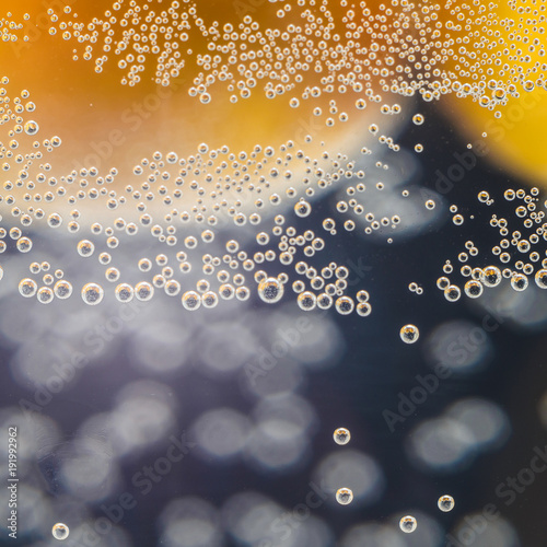 A close-up shot of citrus in a glass of water with lots of bubbles beautiful background for greeting cards and advertising materials.