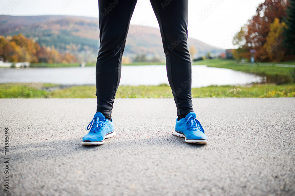 Young runner in autumn park standing on concrete path. Young runner in autumn park standing on concrete path.