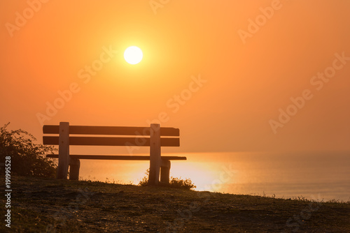 Empty bench with amazing sunrise sea view, peace and calm romantic travel background with copy space © larauhryn