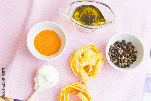 Set of raw ingredients for Italian pasta on a white background. Flour, papper, olive oil. Set of healthy food products. Closeup and top view