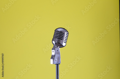 vintage microphone on a yellow isolated background