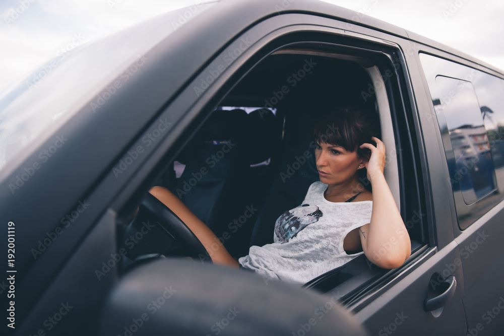 Portrait of a girl sitting in a car stock photo - OFFSET