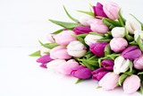 White and pink tulips on white wooden table. Holiday background, copy space