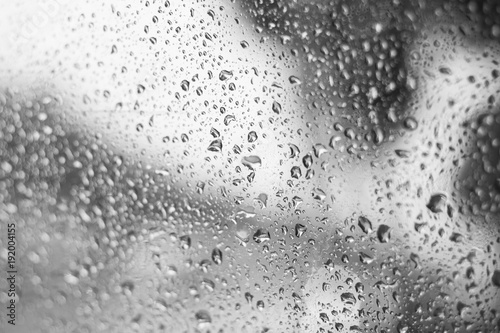 rain water drops on the glass . mirror bokeh background . black and white abstract .