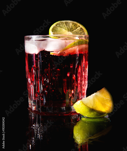 Drink z lodem i limonką na czarnym tle