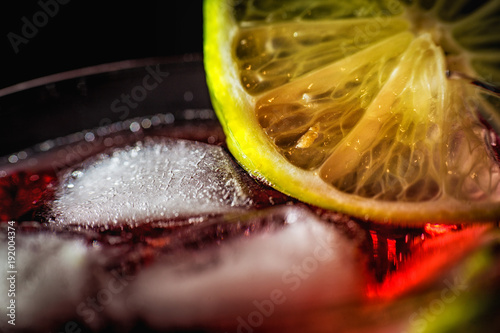 Drink z lodem i limonką na czarnym tle