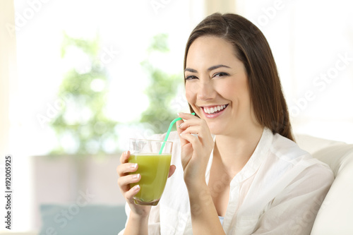 Woman drinking a vegetable juice looking at camera