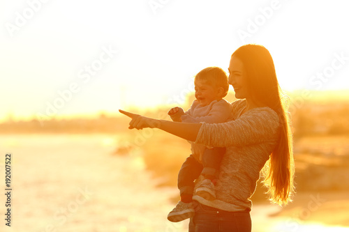 Cuadro en lienzo Happy mother and kid looking away at sunset