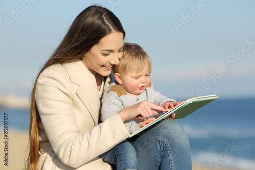 Fotografía Kid learning and mother showing a book