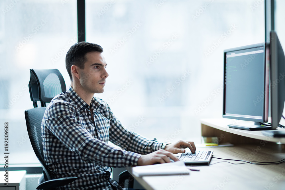 Portrait of young businessman working on computer Portrait of young businessman working on computer