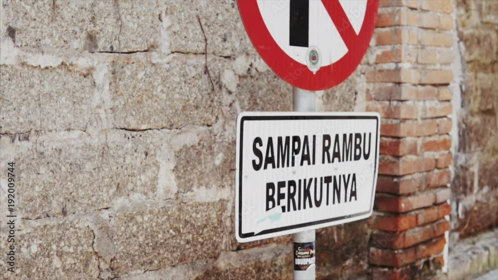 Sign displayed on road to keep people from parking in designated area in Indonesian empty street, Bali, Ubud city at sunny summer day. Camera slowly slide and rotate. Sign displayed on road to keep people from parking in designated area in Indonesian empty street, Bali, Ubud city at sunny summer day. Camera slowly slide and rotate.