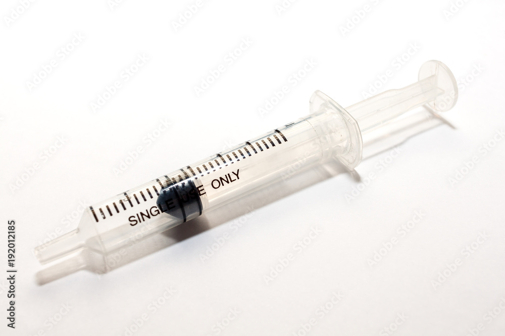 A plastic medical syringe, with out injection needle on white background. A plastic medical syringe, with out injection needle on white background.