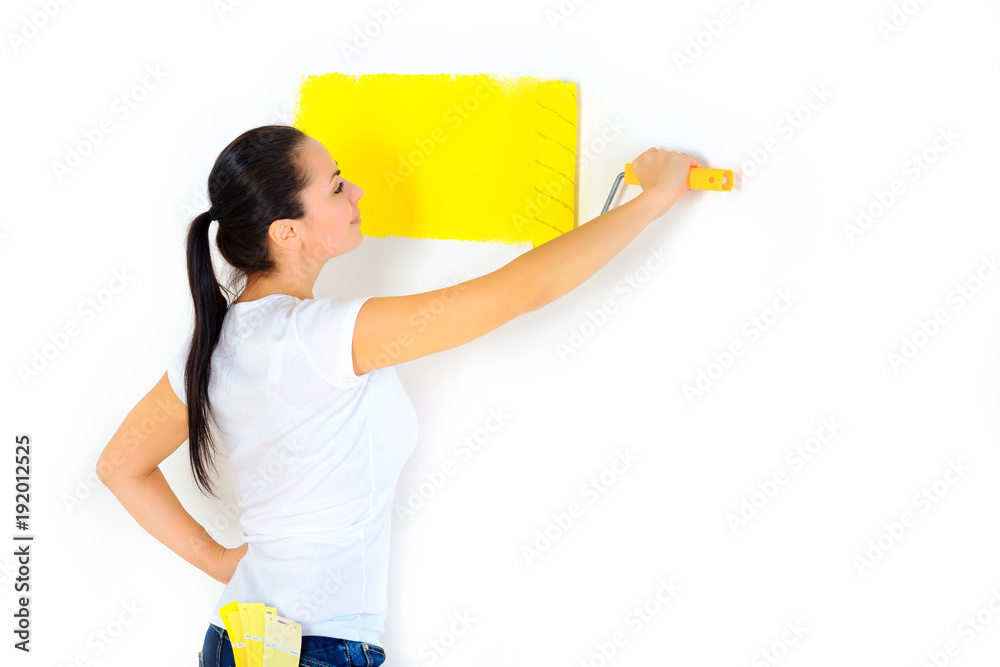 girl painter paints the wall with a roller, repairs in the house girl painter paints the wall with a roller, repairs in the house