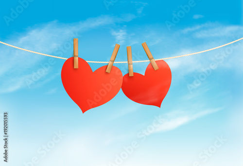 Two hearts hanging on a rope in front of a sky. Valentine's day vector.