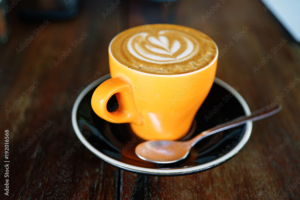 Orange coffee cup on a wooden table in a cafe. Summer terrace. Side view with copy space Orange coffee cup on a wooden table in a cafe. Summer terrace. Side view with copy space