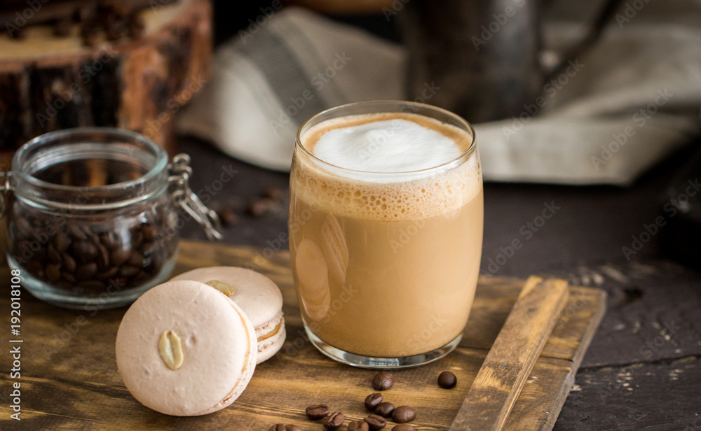 Φωτογραφία The perfect tasty breakfast!) The cup of latte or cappuccino coffee with milk and peanut, vanilla macarons on a wooden cutting board