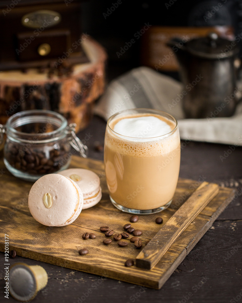 Φωτογραφία The perfect tasty breakfast!) The cup of latte or cappuccino coffee with milk and peanut, vanilla macarons on a wooden cutting board