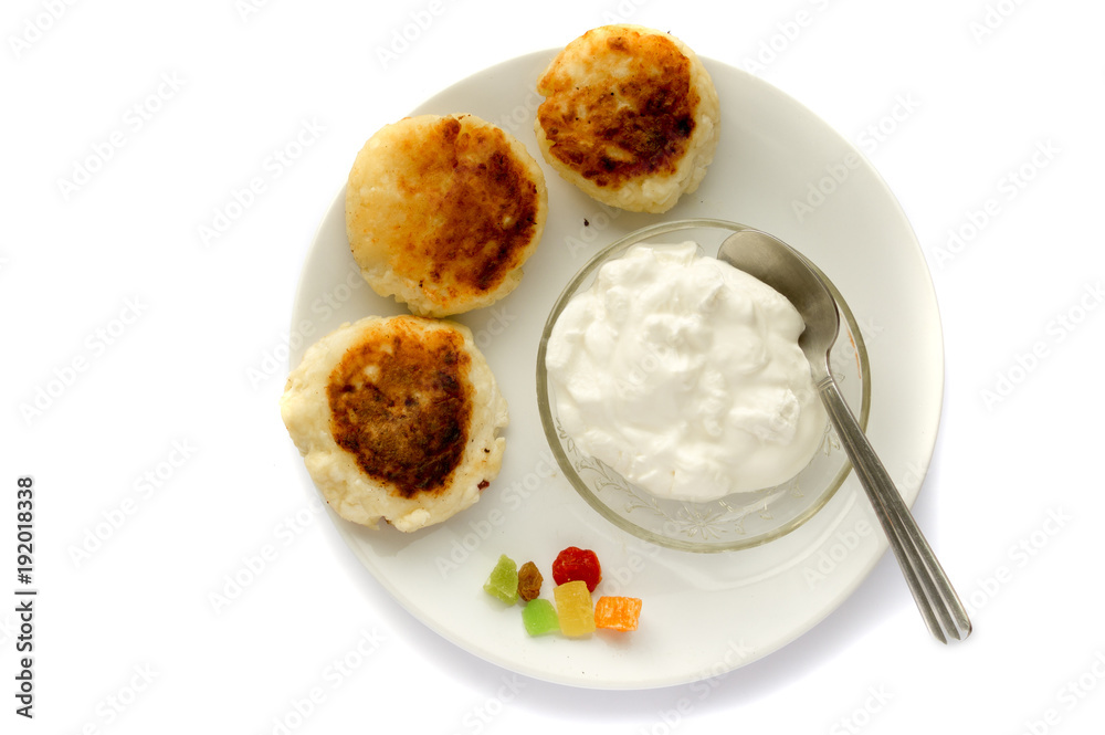 cheese cake on white plate with sour cream on white background
