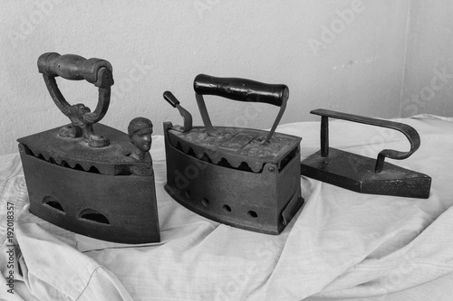 three vintage irons /three old irons made of cast-iron on a shirt