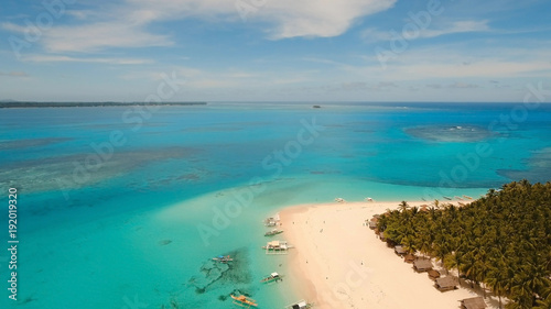 Aerial view of beautiful tropical island Daco with white sand beach. View of a nice tropical beach from the air. Beautiful sky, sea, resort. Seascape: Ocean and beautiful beach paradise. Philippines
