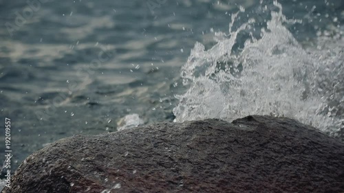 Slow motion abstract wave crashing over rock shallow depth of field video clip