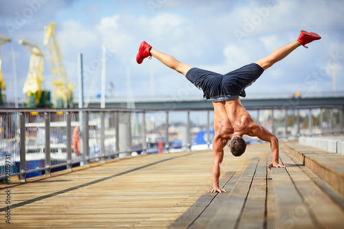 Valokuva Athletic man doing a handstand exercise during an outdoors workout in the city