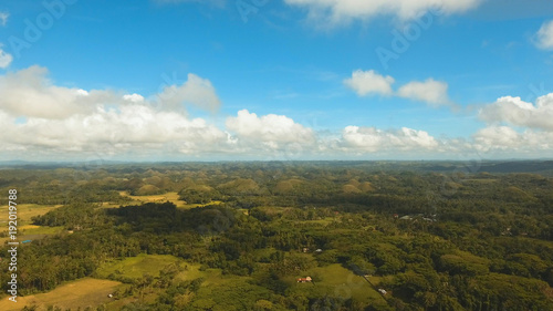 Amazingly shaped Chocolate hills on sunny day on Bohol island, Philippines. Aerial view Chocolate Hills in Bohol, Philippines are earth mounds scattered all over the town of Carmen. Travel concept.