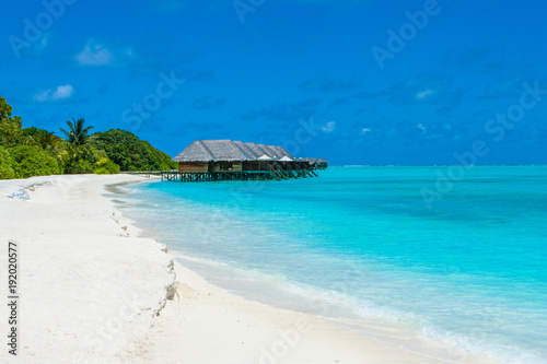 Fototapeta Naklejka Na Ścianę i Meble -  Beautiful sandy beach and over water tropical bungalo