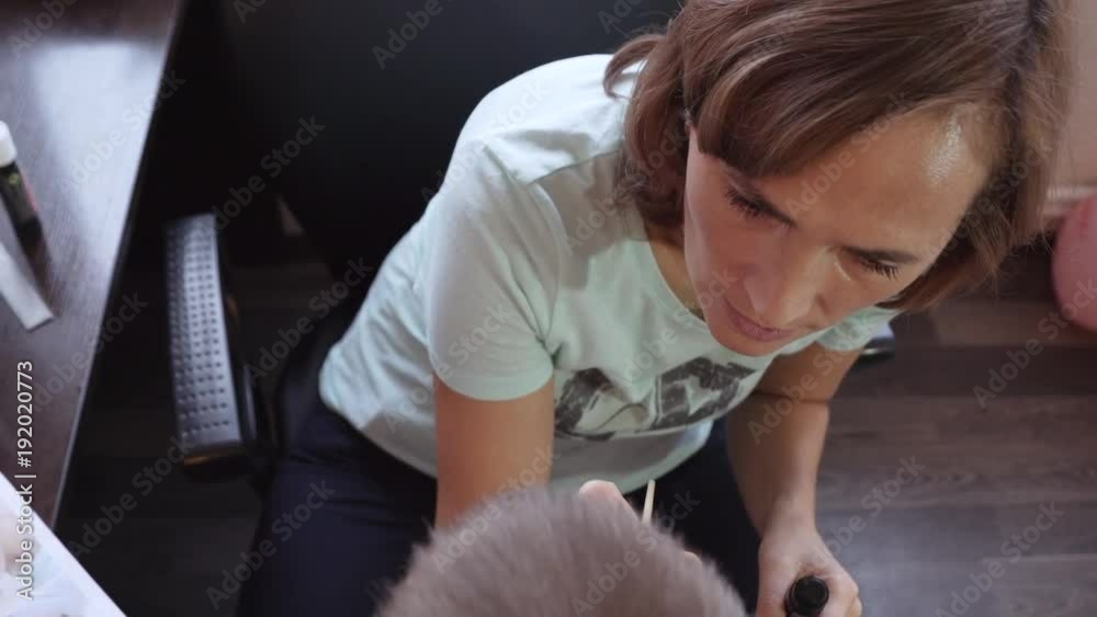A pretty woman with a brush draws on her son's face. Aquagrim. Drawing on the body. A pretty woman with a brush draws on her son's face. Aquagrim. Drawing on the body.