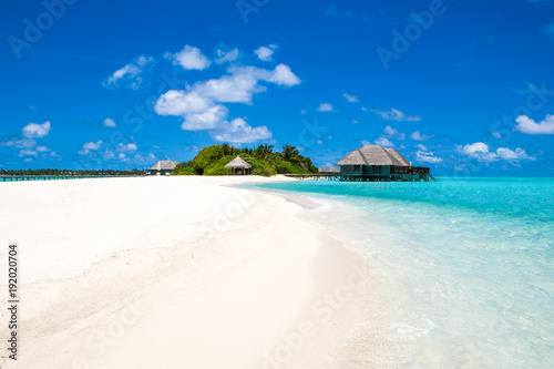 Beautiful sandy beach and over water tropical bungalo © Myroslava