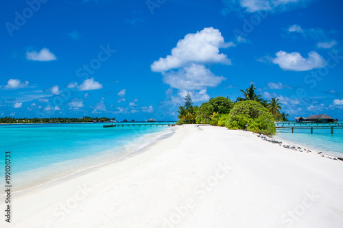 Fototapeta Naklejka Na Ścianę i Meble -  Beautiful sandy beach and over water tropical bungalo