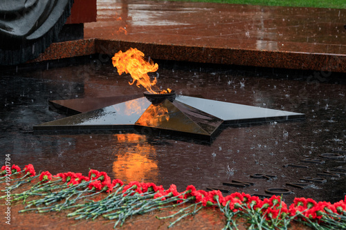 Rainy view of the Tomb of Unknown soldier and Eternal flame in Alexander garden near Kremlin wall in Moscow, Russia.