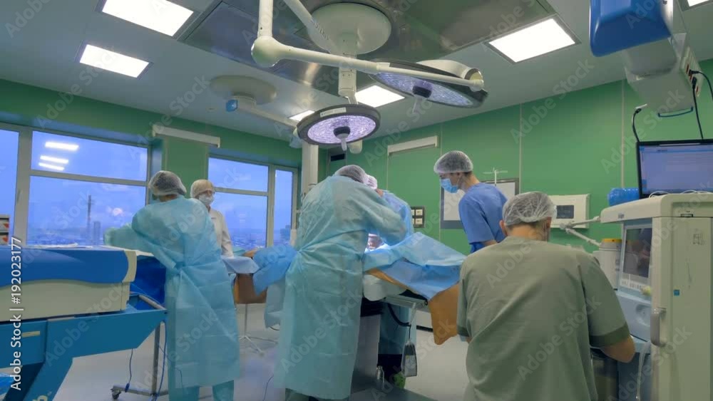 Wide angle view of doctors team perfoming a surgery. 4K. Wide angle view of doctors team perfoming a surgery. 4K.