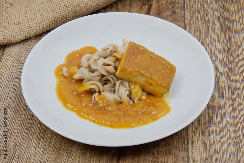 Tofu and pumpkin sauce with pasta on a table