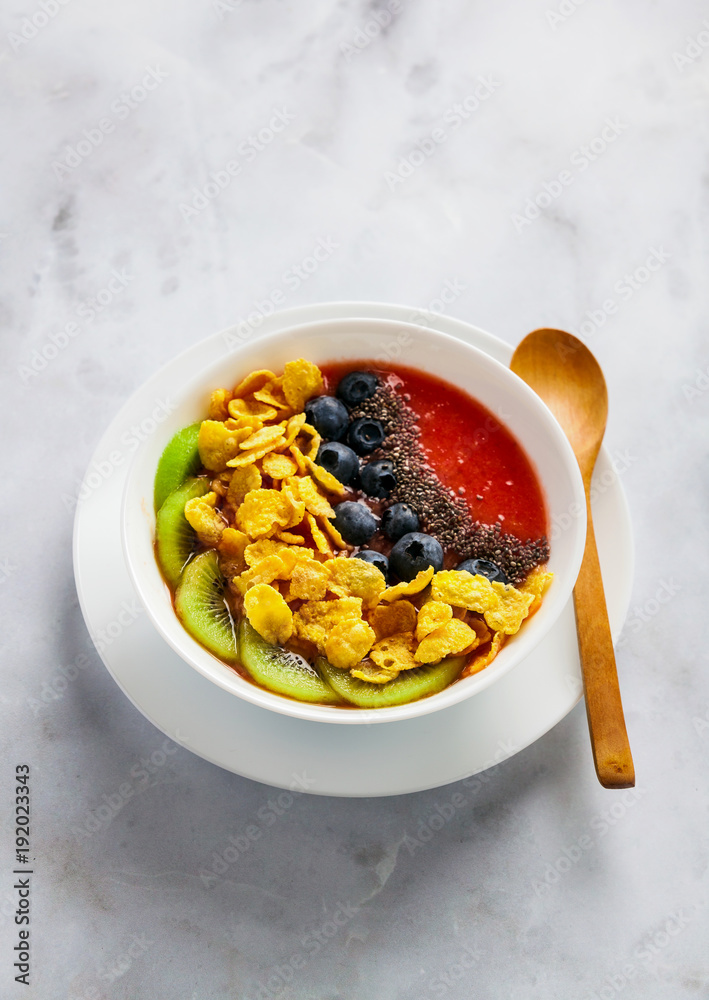 a bowl of smoothies, with cereals for a healthy breakfast and berries, chia  seeds and coconut