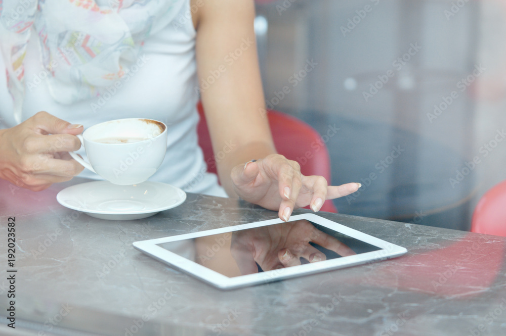 Woman use a touch pad screen while standing in cafe Woman use a touch pad screen while standing in cafe