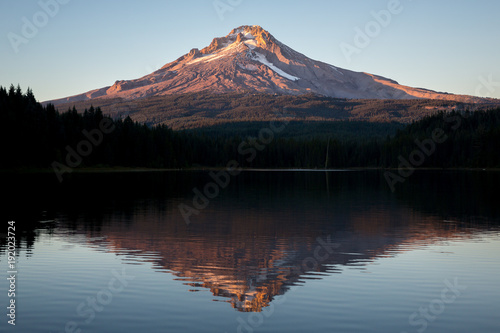 A view of a mountain over a lake at sunset photo
