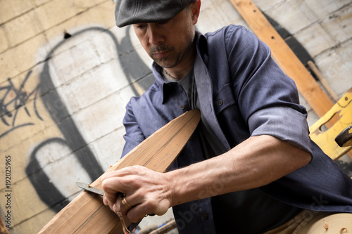 Man carving a boat oar