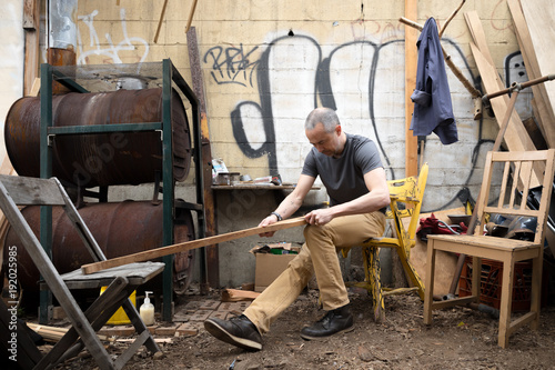 Man carving a boat oar photo