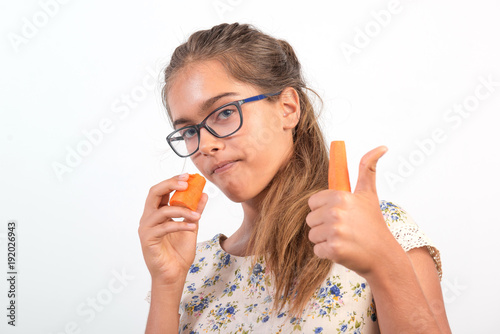 beautiful girl with carrot. Vitamins for teenagers. Vegetabl for healthy eating of children. Positive weight loss. girl with glasses. girl bites a carrot. Natural vitamins to improve vision. 